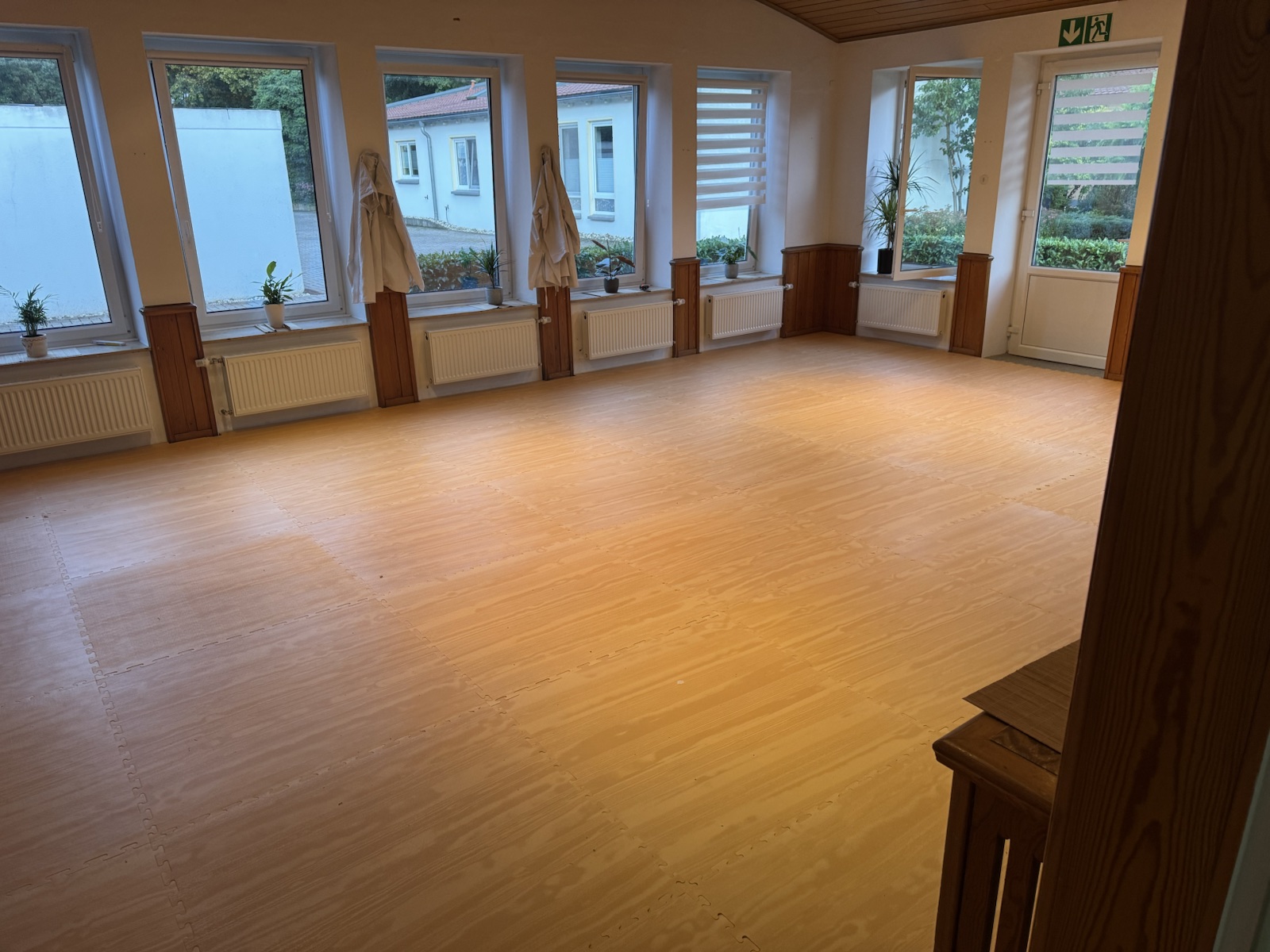 Heller Trainingsraum der Karateschule Lahde mit Holzoptik-Boden und großen Fenstern