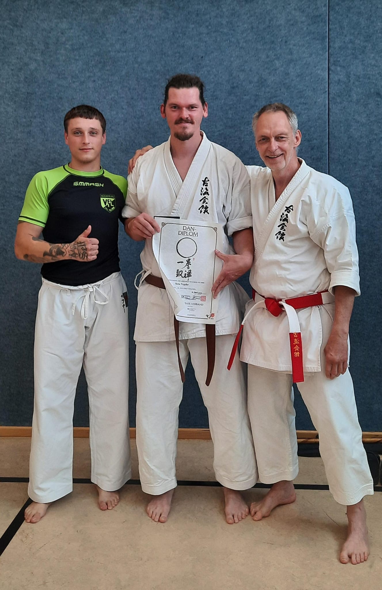 Rene Tegeler mit Dan-Diplom zwischen seinem Prüfungspartner Marcel und Trainer Dr. Andreas Höfner
